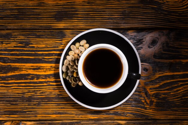 Top down view of coffee with beans in saucer