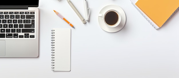 A top down view of a white office desk with an empty notebook computer keyboard and various other