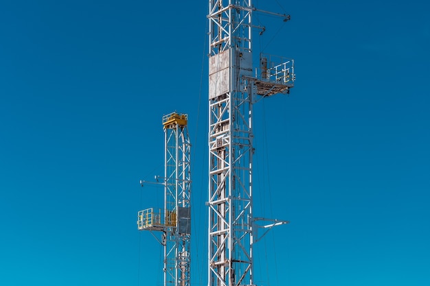 Top of drilling towers with blue sky background.