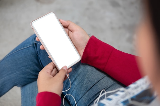 Top of female holding mockup smartphone on hands.