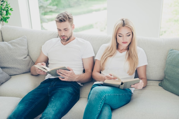 Top above high angle view of couple in white tshirts and jeans reading book