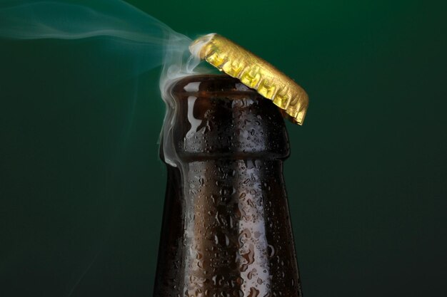 Photo top of open wet beer bottle on dark background