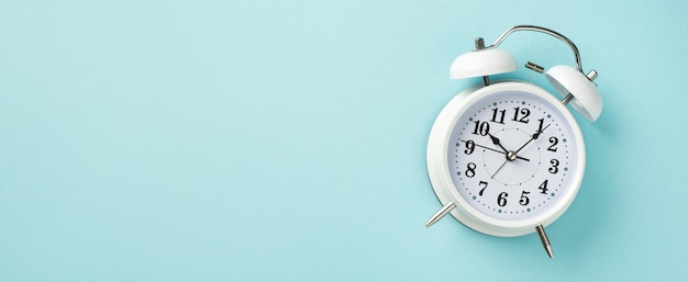 Top overhead panoramic close up view photo of classic white alarm clock showing time isolated pastel color backdrop with blank space