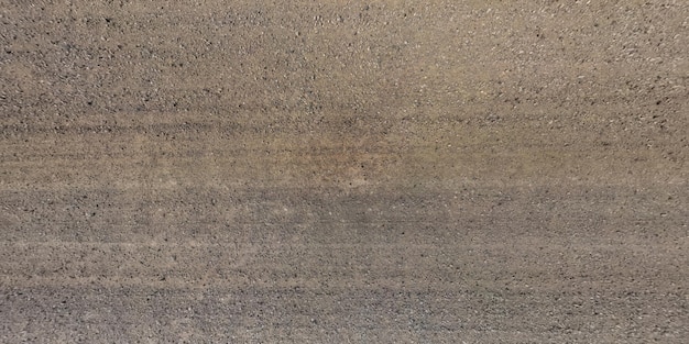 Top panorama view from above on surface of gravel road with car tire tracks