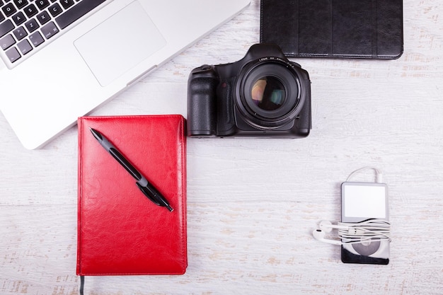 Over top photo of DSLR digital camera and laptop on wooden background