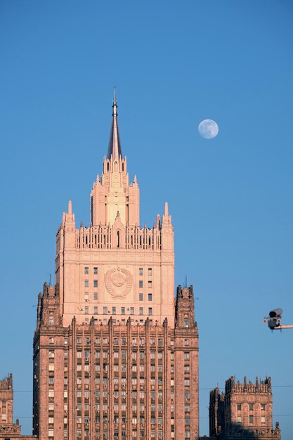 Top of Russian Christian church colored pink with cupolas with golden crosses over blue sky