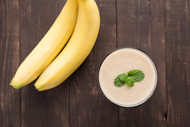 Top shot banana smoothie on wooden table