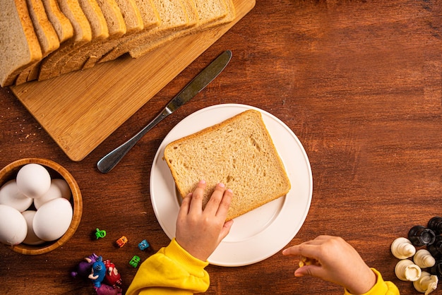 사진 버터 미소를 곁들인 아침 식탁 빵 슬라이스 버터 빵의 탑 샷 키즈 핸드 조식 12월