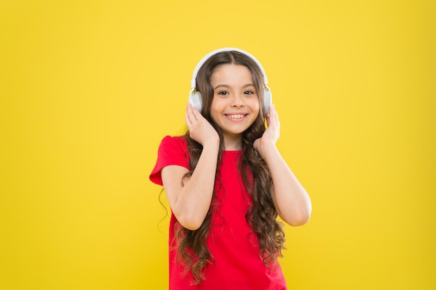 Top songs Child teen enjoy music playing in earphones Little girl enjoying favorite music Catch the rhythm Kid listening music headphones Entertainment and fun Excellent audio sound quality