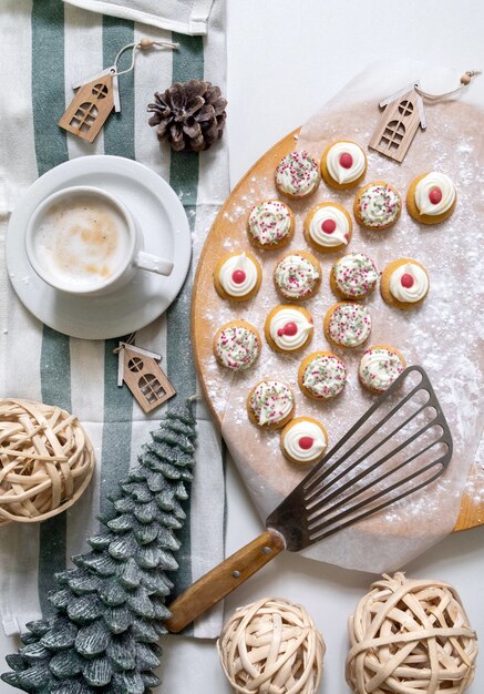 Foto top uitzicht op taarten voor het nieuwjaar en kerstmis met een kop koffie op de witte tafel