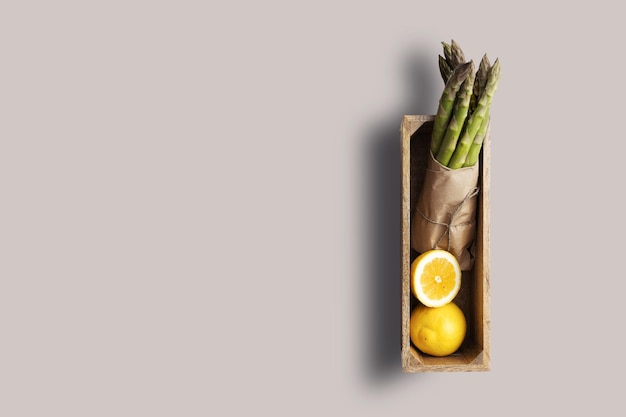 Top up up view lemon and asparagus isolated on wooden background suitable for your design project