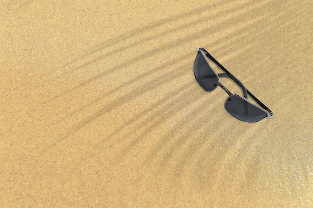 Top up view of black sunglasses on sand beach vacation concept background