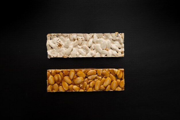 Top view of 2 different types of Spanish Turrons on black background.