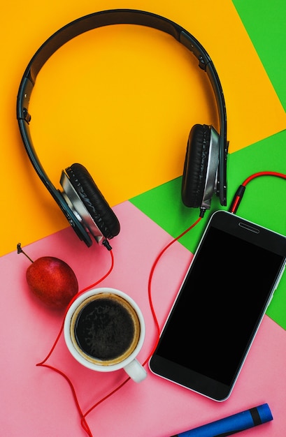 Top view accessories office desk.smartphones headphones on colorful background