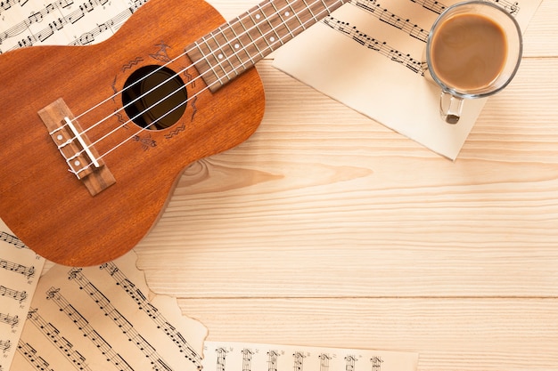 Top view acoustic guitar with wooden background