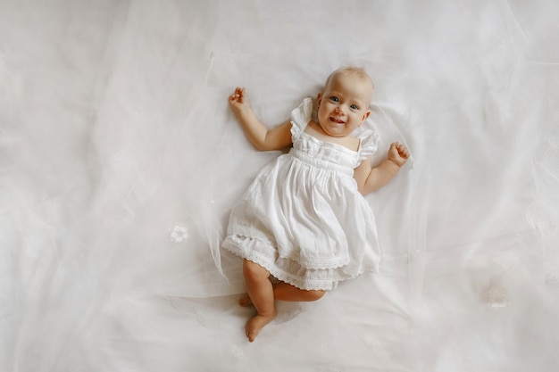 Top view on the adorable female baby lying on the bed