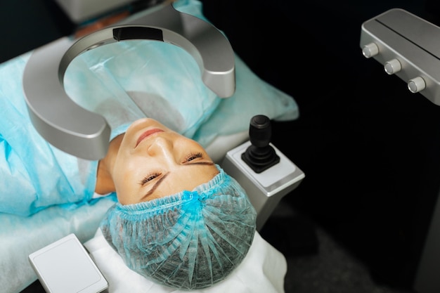 Top view of an adult female patient being ready for the procedure in the hospital