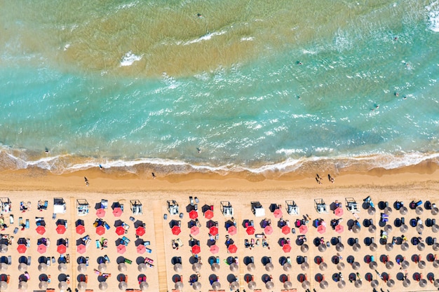 写真 美しいターコイズブルーの海の波と赤い傘とバナナビーチの平面図空中ドローン写真休暇旅行の背景イオニア海ザキントス島ギリシャ