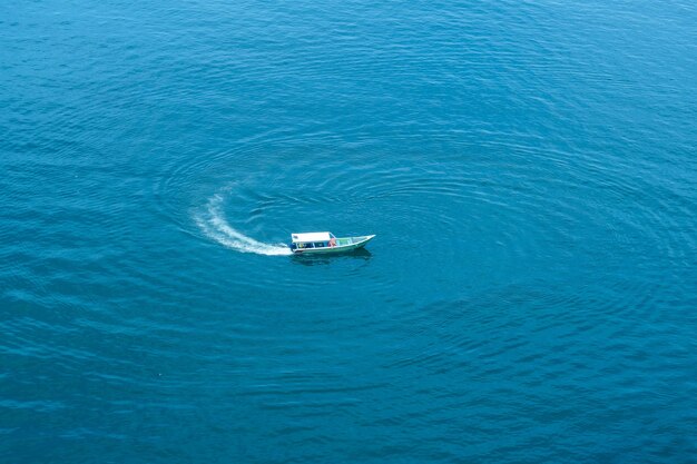 Top view aerial view wooden fishing boat on the beach from a drone royalty high quality stock photo image of the wooden fishing boat on the beach fishing boat is mooring on clear blue beach alone