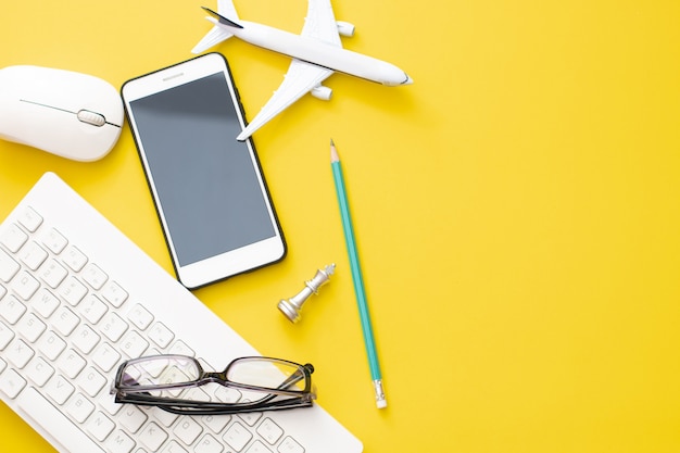 Aeroplano di vista superiore con gli occhiali e lo smartphone con la matita