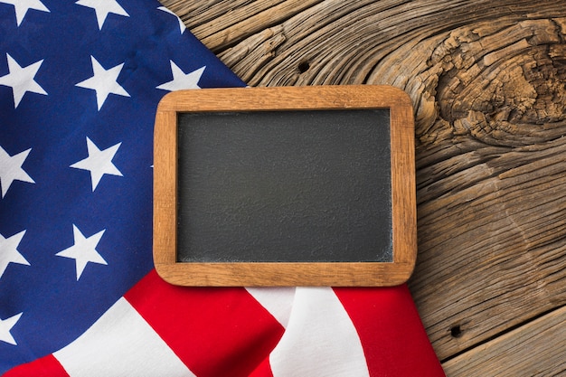 Top view of american flag and blackboard on wood