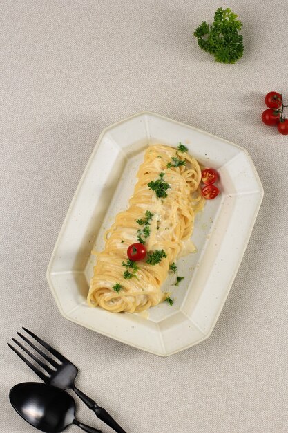 Top view angel hair pasta con salsa cremosa alla carbonara, spaghetti alla carbonara con parmigiano. servito su piatto rettangolare