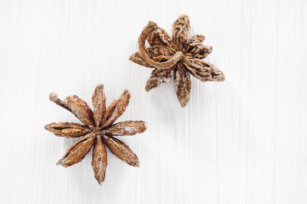 Top view: anise stars on white wooden surface