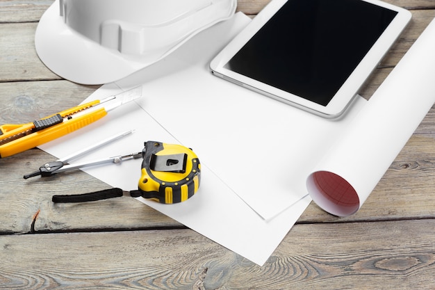 top view of architect workplace with blueprint paper and digital tablet with blank screen