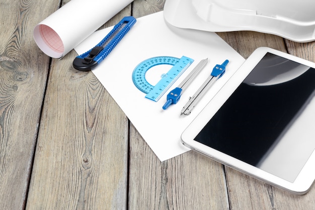 top view of architect workplace with blueprint paper and digital tablet with blank screen