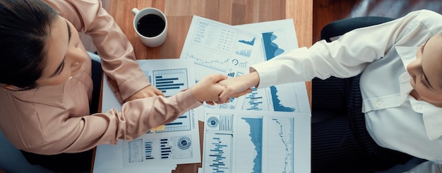 Photo top view asian businesswomen handshake over desk enthusiastic