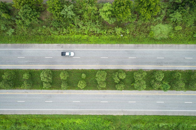 緑色の若い田んぼの中にあるトップアスファルト道路