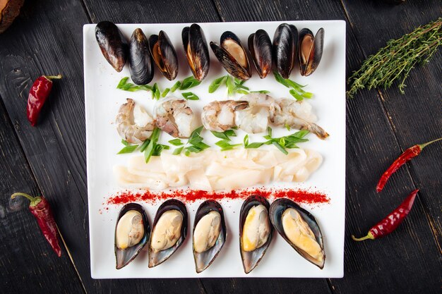 Top view on assorted seafood platter on the dark wooden table