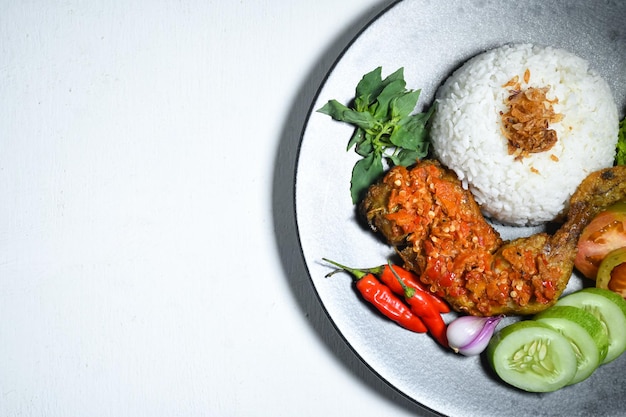 Photo top view ayam geprek indonesian food with sambal hot chili sauce served rice on black plate