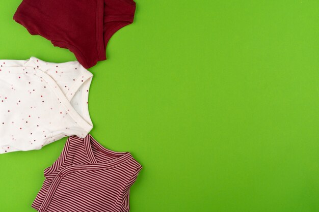 Top view of baby clothes on green surface