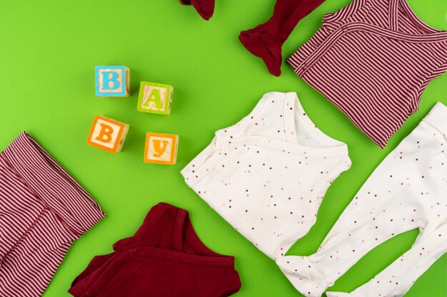 Top view of baby clothes on green 