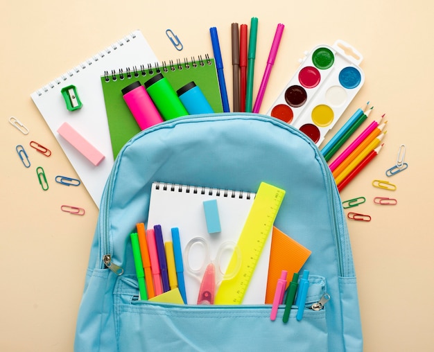 Top view of back to school stationery with backpack and colored pencils