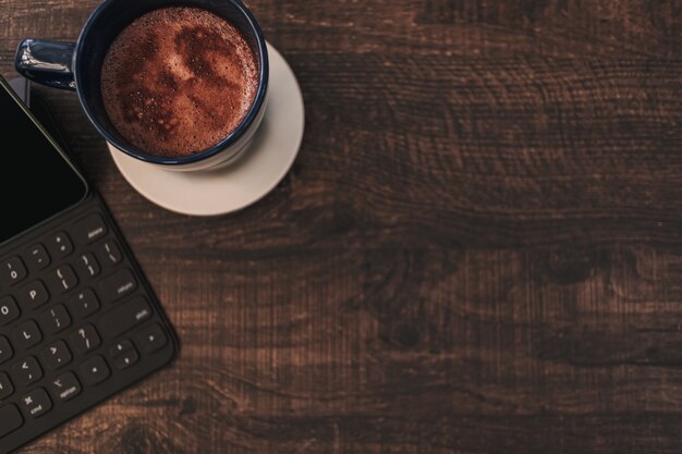 Top view background of tablet and hot drink on wooden desk