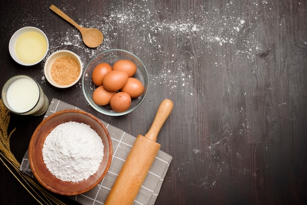 Top view of bakery ingredients on black wooden table