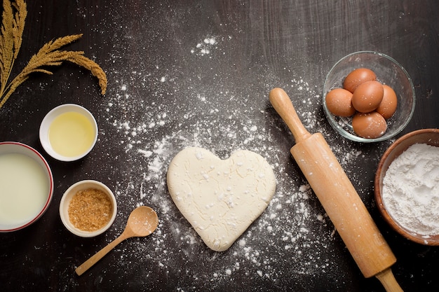 Top view of bakery ingredients on black wooden table