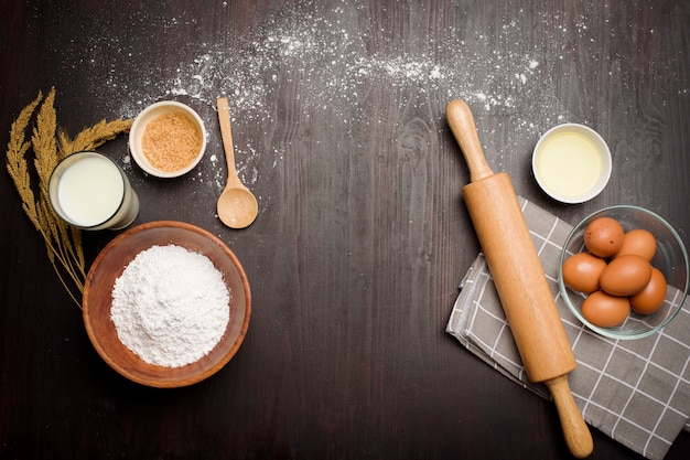 Top view of bakery ingredients on black wooden table