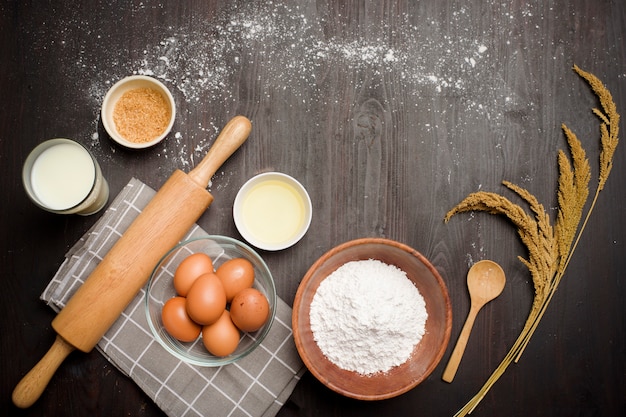 Top view of bakery ingredients on black wooden table