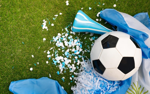 Top view of a ball a vuvuzela and light blue and white party favors