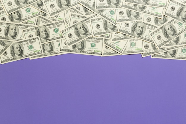 Top view banknotes on colored desk with copy space on top. one hundred dollar bills with stack of money in the middle. Top view of business concept