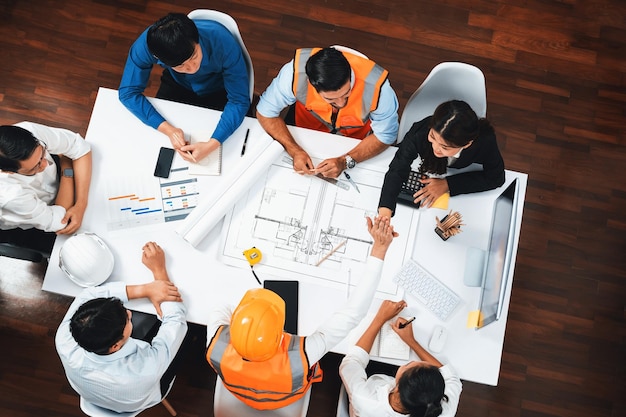 Photo top view banner of diverse group of civil engineer and client working together on architectural project reviewing construction plan and building blueprint at meeting table prudent