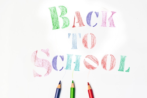 Top view banner message back to school with color pencil items\
for the school on white background