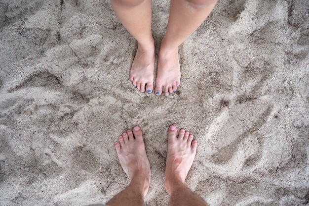 Top view of Barefoot couple standing together on the beach in vacation