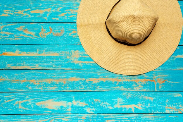 Top view beach hat on blue wood