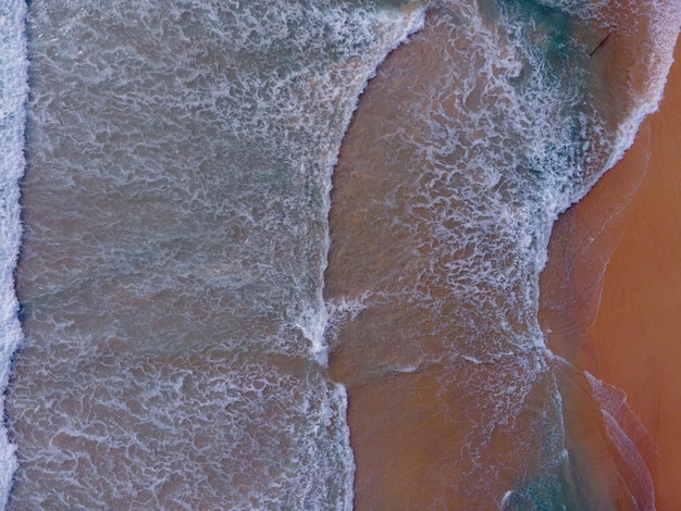 Photo top view beach and seawater crystal water wave on sandy beach in summer.