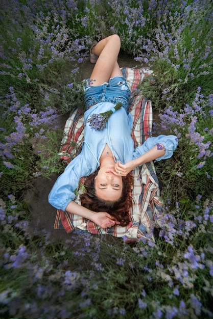 Фото Вид сверху, красивая сексуальная девушка, лежащая в лавандовом поле, время расслабиться и расслабиться