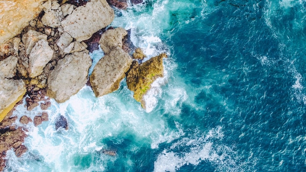 Top view of beautiful waves crashing on the cliffs of the Kesirat beach